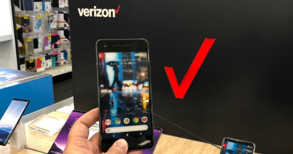 hand holding google pixel phone in front of verzion sign