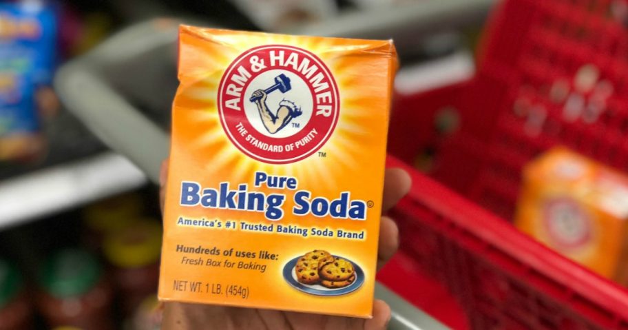 hand holding a box of arm & hammer baking soda