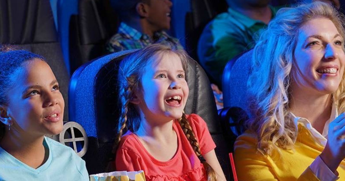 Kids smiling while watching a movie in the theater