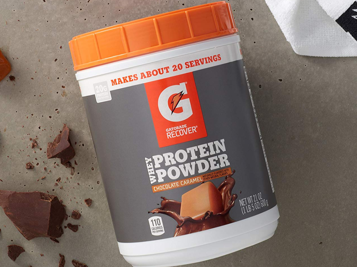 Gatorade Whey Protein Powder Chocolate Caramel Container on cement with Chocolate chunks