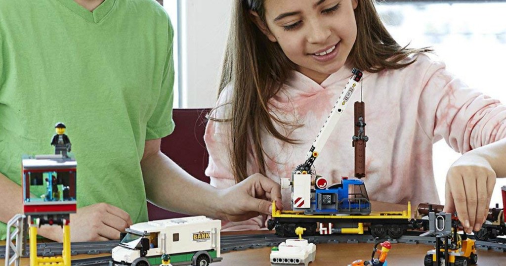 boy and girl playing with lego train set