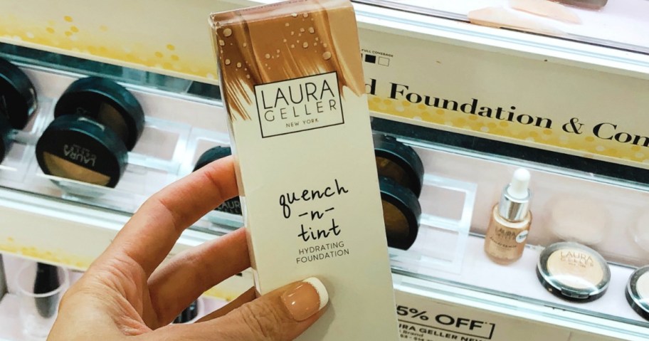 manicured hand holding box of foundation in makeup store