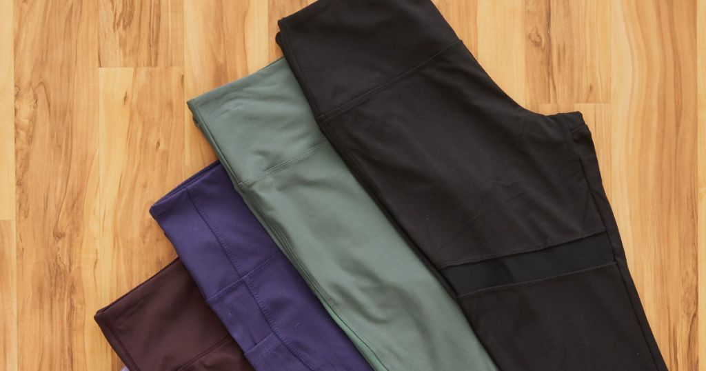 black, olive, blue, and plum marika leggings on wood floor