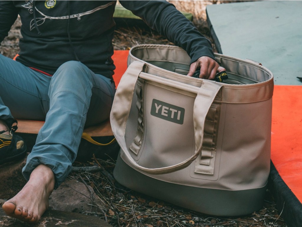 hand grabbing something from YETI tan Bag