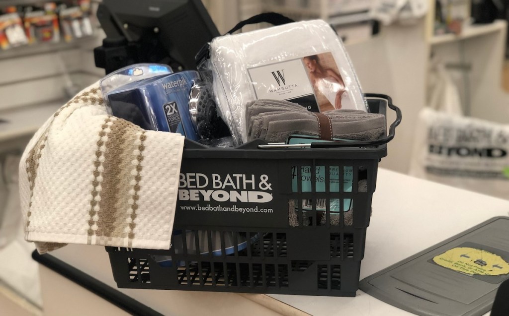 bed bath and beyond basket with towels and sheets inside on store checkout counter