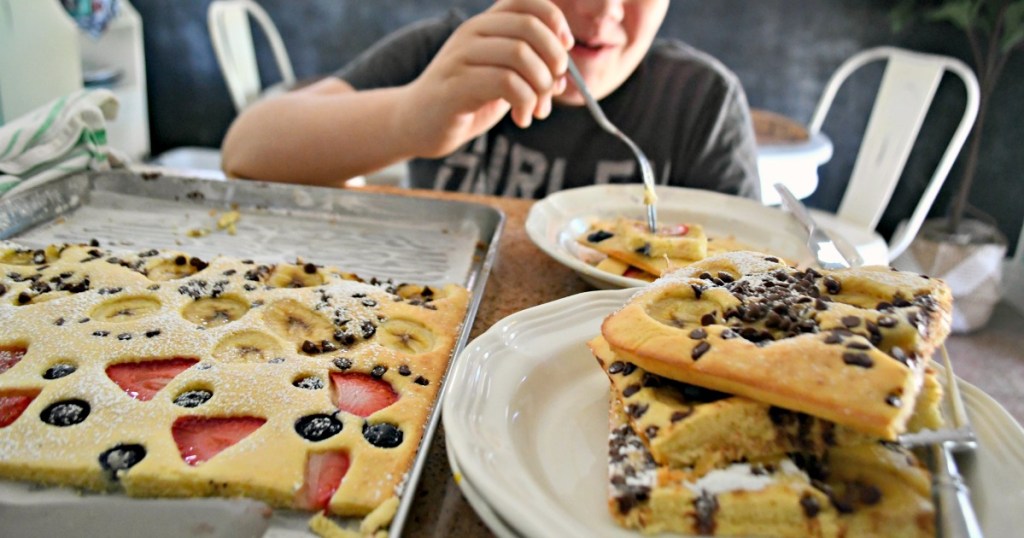 boy taking a bite of sheet pan pancakes