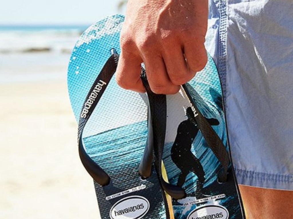 man holding pair of sandals