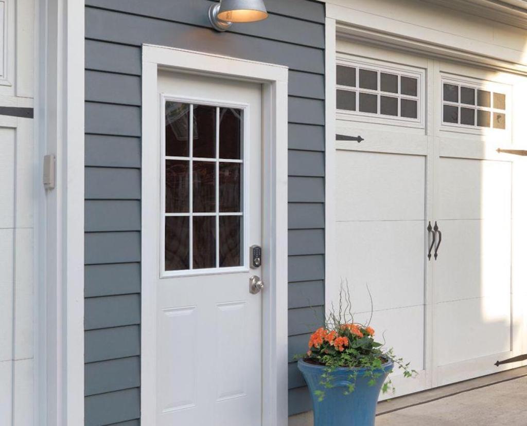 blue house with white trim and flower pot on sidewalk