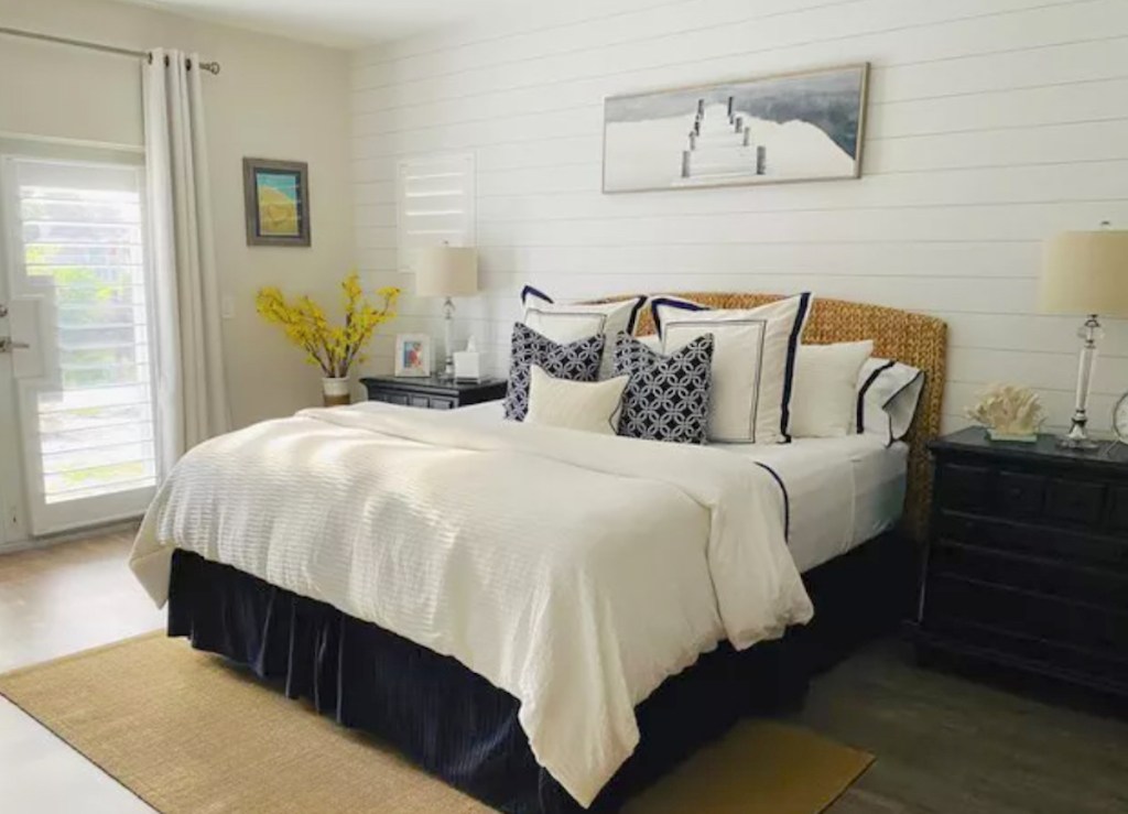 coastal style bedroom with pillows artwork and shiplap wall