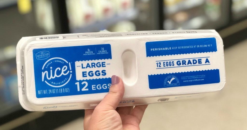 hand holding white egg carton 