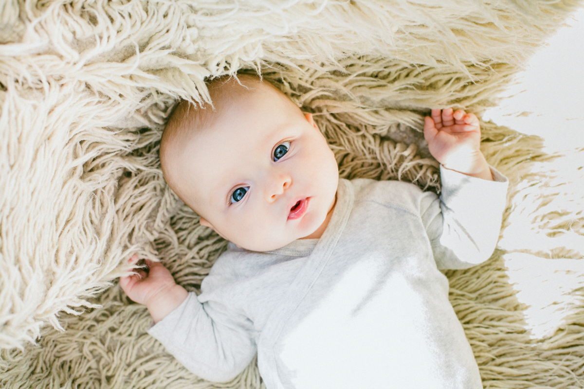 infant laying on a lambskin