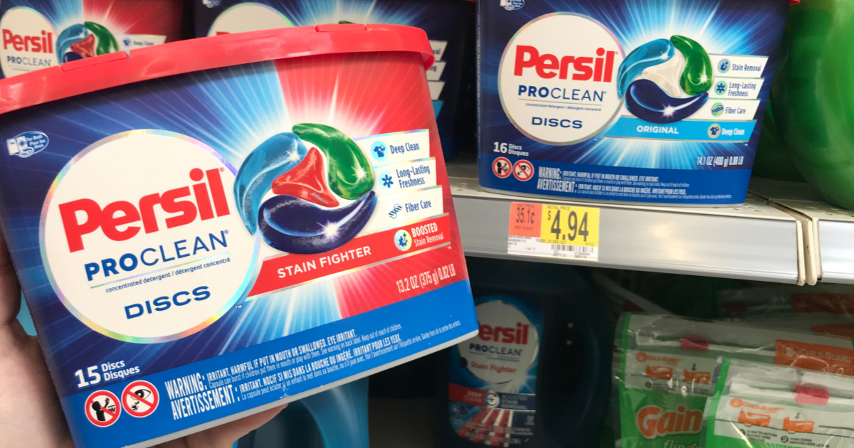 hand holding a package of persil pods in front of a display shelf