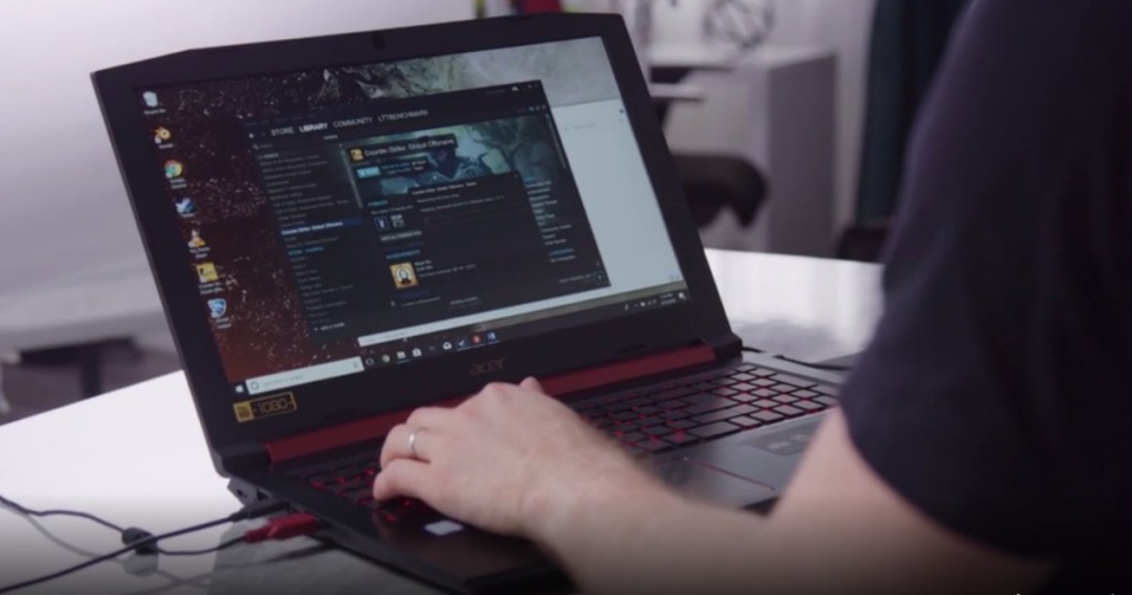  man sitting at desk typing on laptop