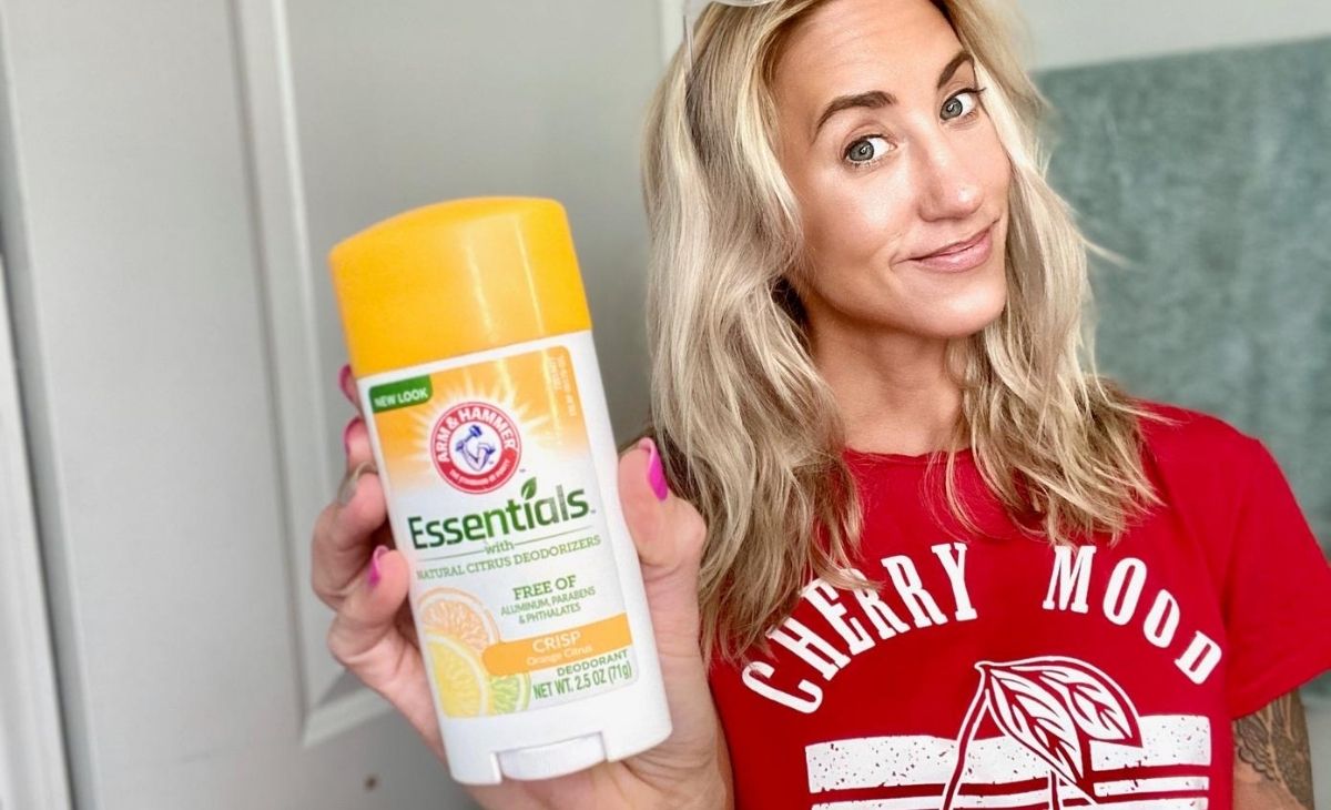 A woman holding deodorant in a bathroom