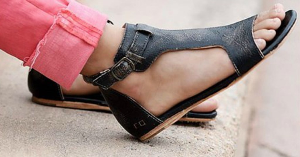 leg wearing pink jeans and black sandals 