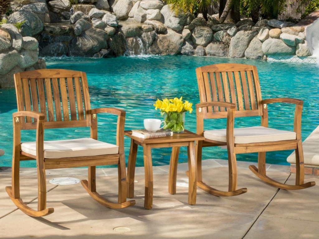 Christopher Knight Teak Rocking Chair Set in front of pool