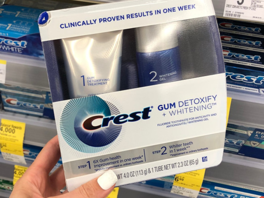 Woman holding Crest Gum Detoxify + Whitening Two-Step toothpaste at Walgreens