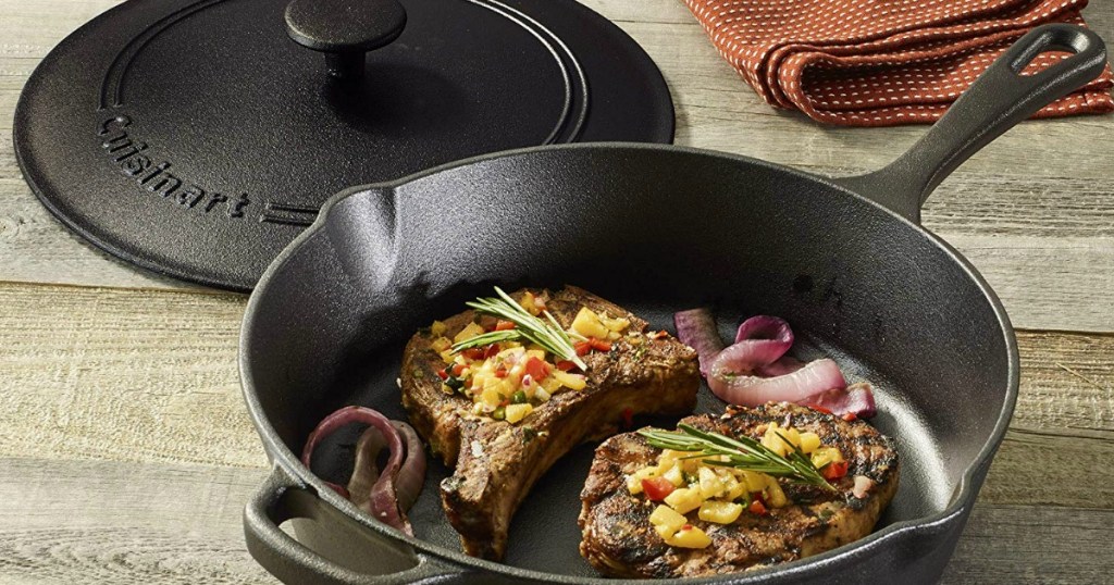 cast iron pan with steaks and onions in it