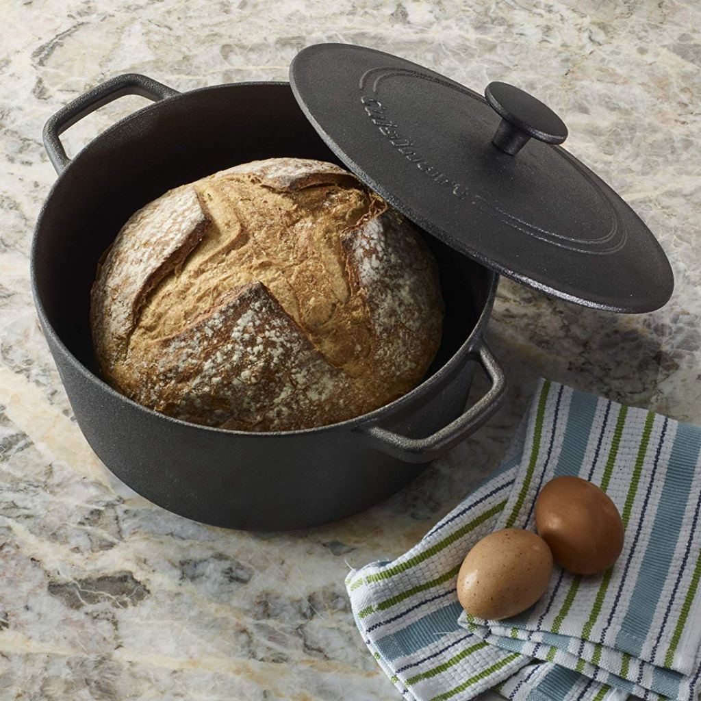 cast iron pan with bread inside and eggs on a towel next to it