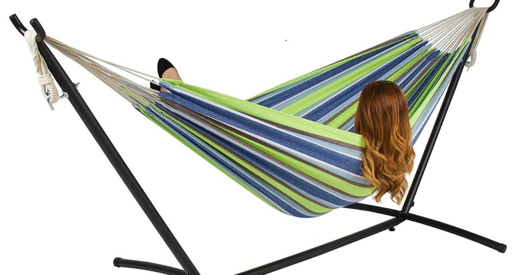 girl laying in blue, green and white striped hammock on metal stand