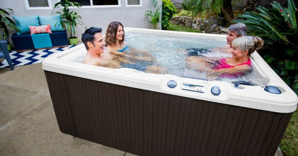 two couples sitting in Lifesmart Plus 5-Person Spa on a patio