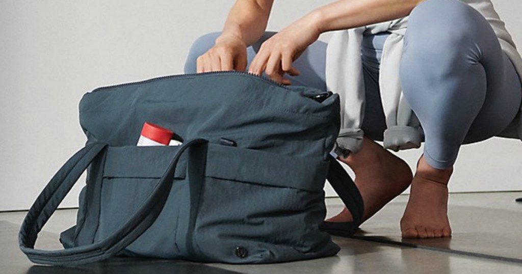 Woman kneeling by Lululemon gym bag