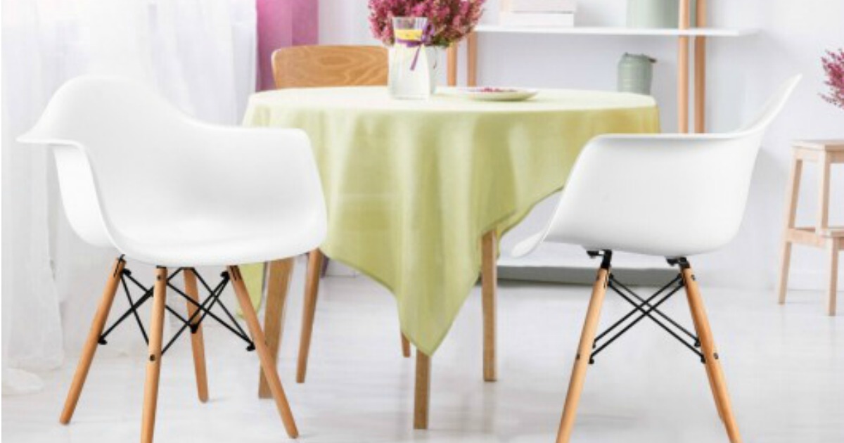 two white mid-century modern chairs with wooden legs, placed around a table