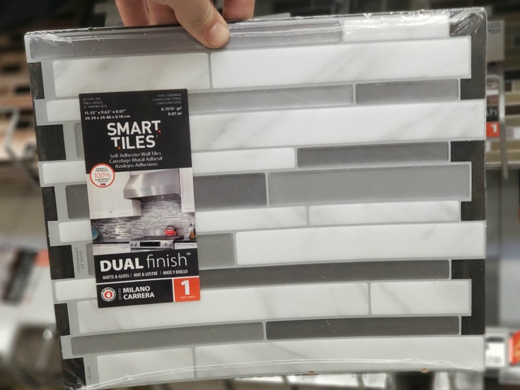 hand holding tile with white and grey by store display