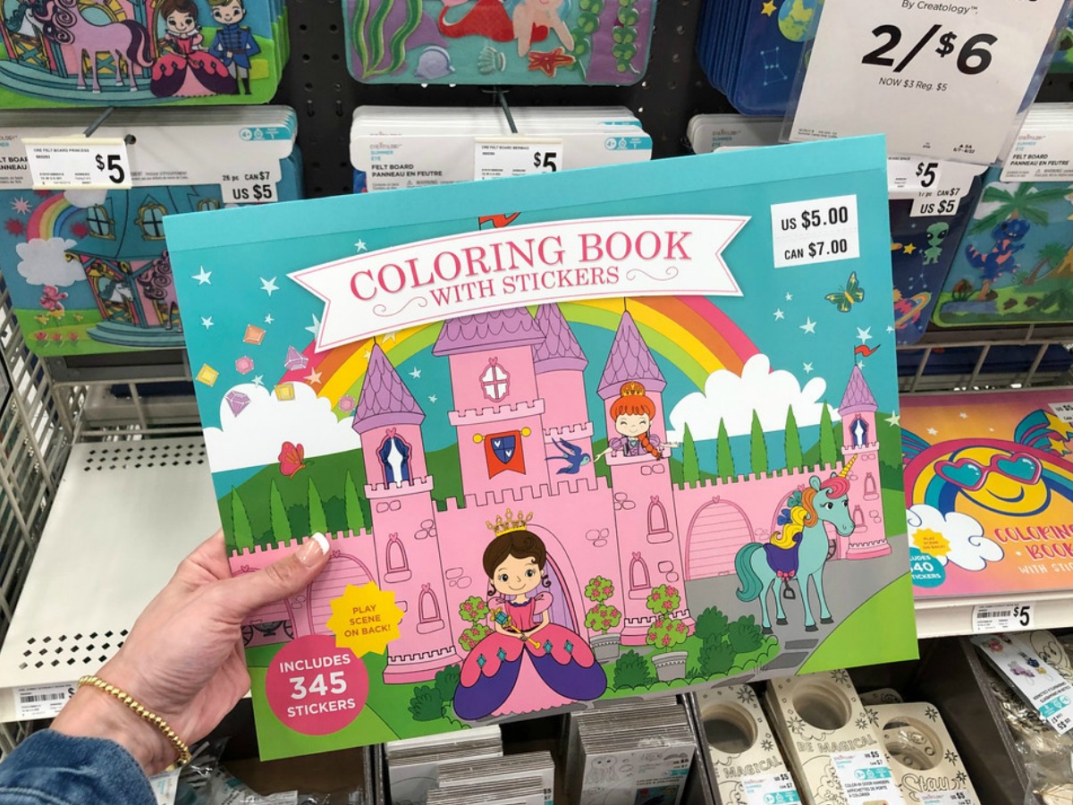 person holding a Creatology coloring book with stickers at Michaels