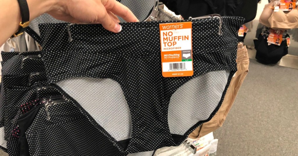 Woman holding Warner's black and white polka dot undies on hanger at Kohl's