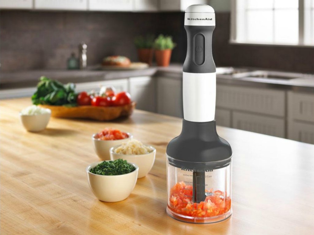 kitchenaid mixer on chopper attachment on kitchen counter next to prep bowls