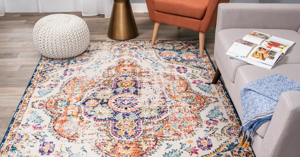 A rug in a family room with a couch and orange chair