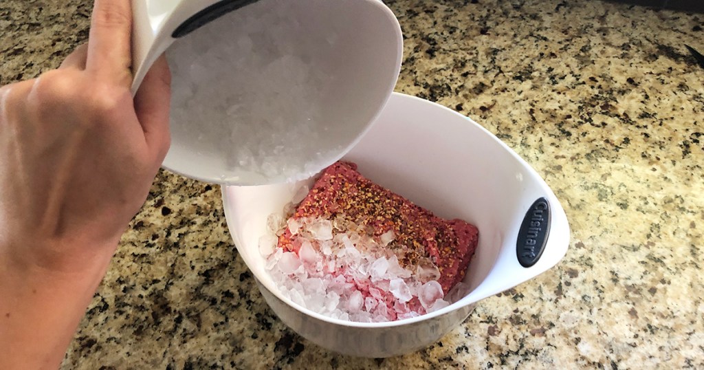 pouring in crushed ice to ground beef for burgers