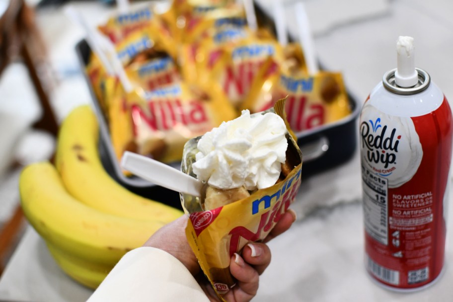 adding whipped cream to a walking banana pudding 