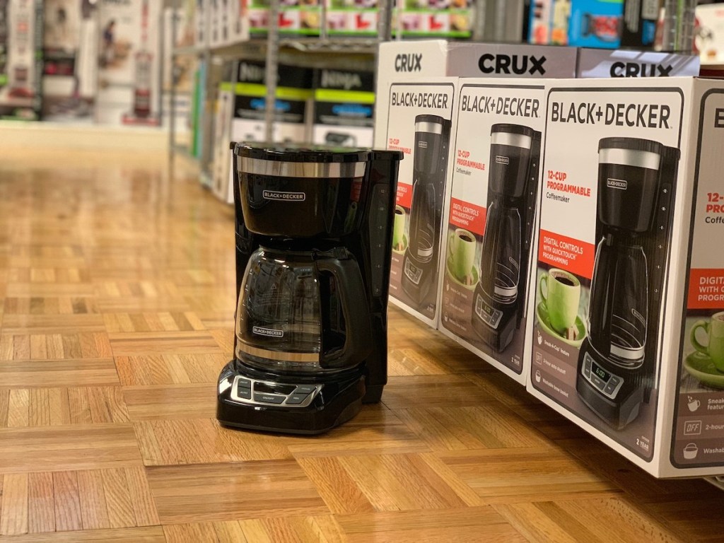 black and decker coffee pot on wood floor in front of product boxes