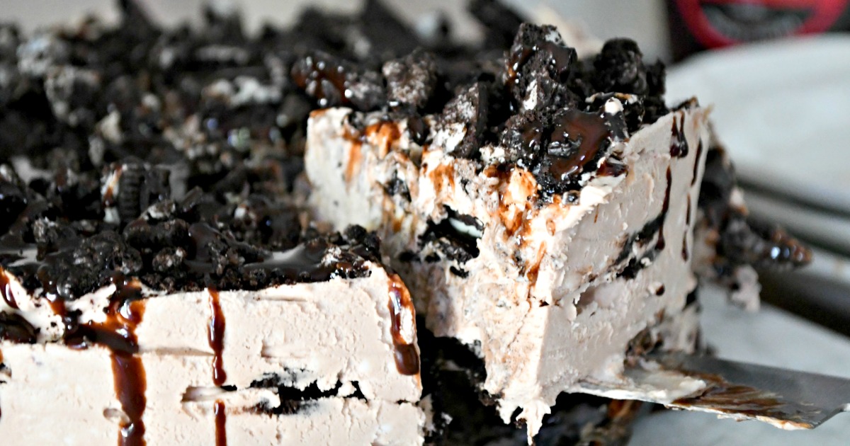 cutting a slice of oreo ice box cake 