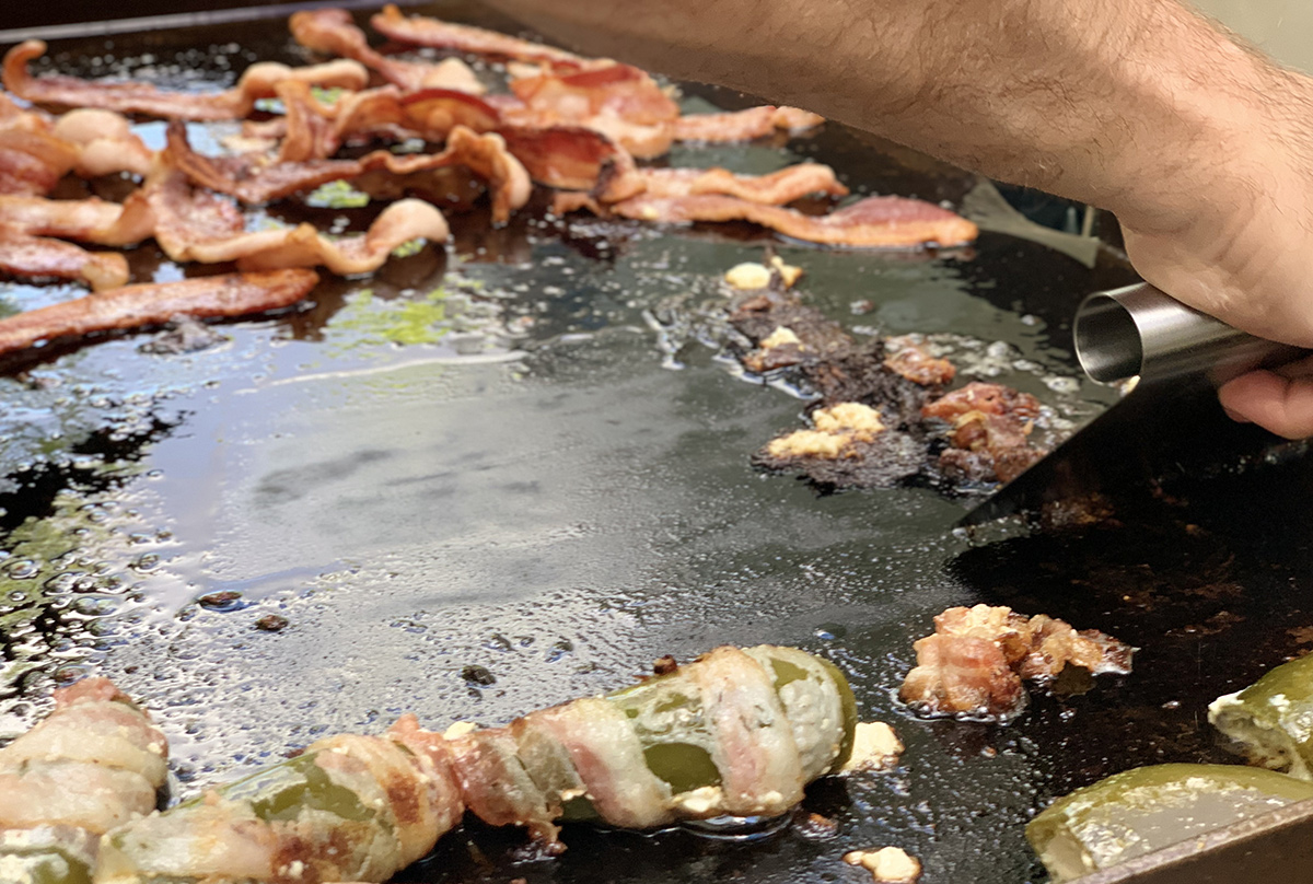 cleaning griddle with flat edge scraper