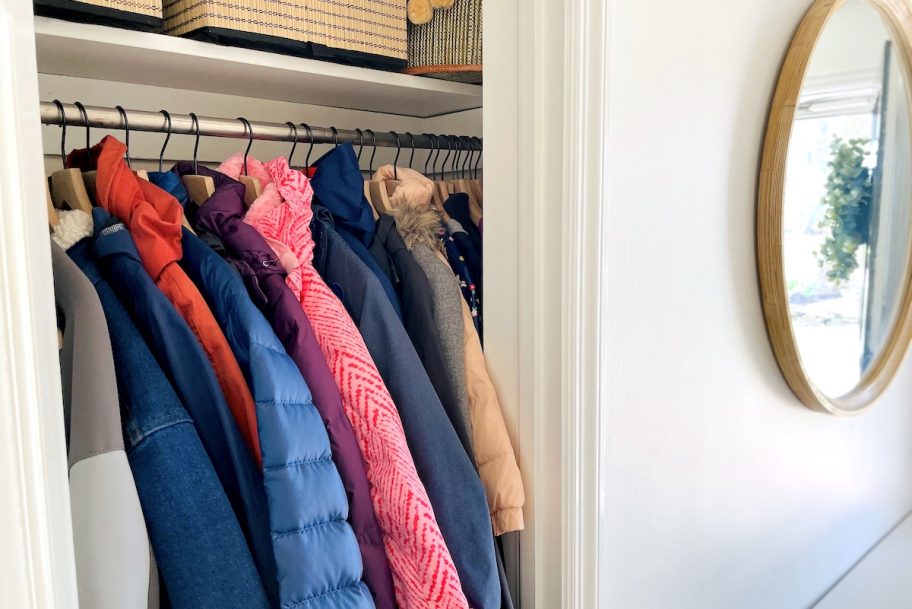 inside of coat closet in foyer hallway with round mirror