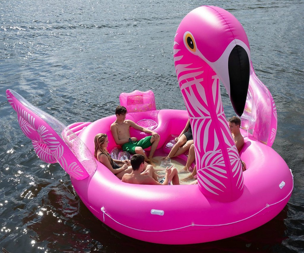 huge inflatable flamingo party float on the ocean with people lounging