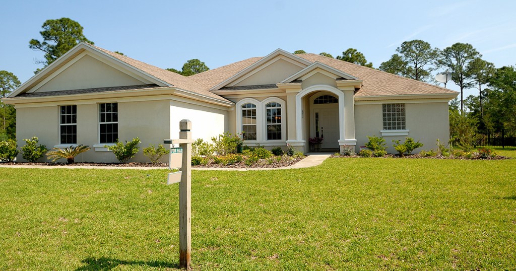 front of home with for sale sign in lawn