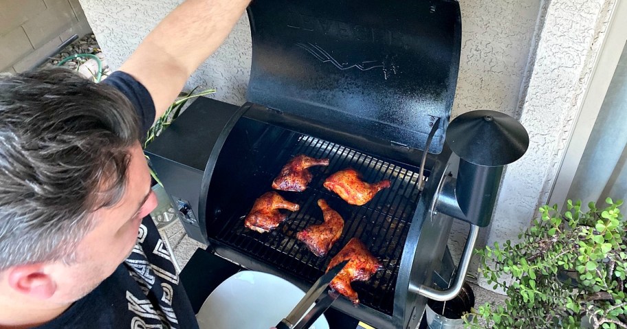 man using the traeger smoker