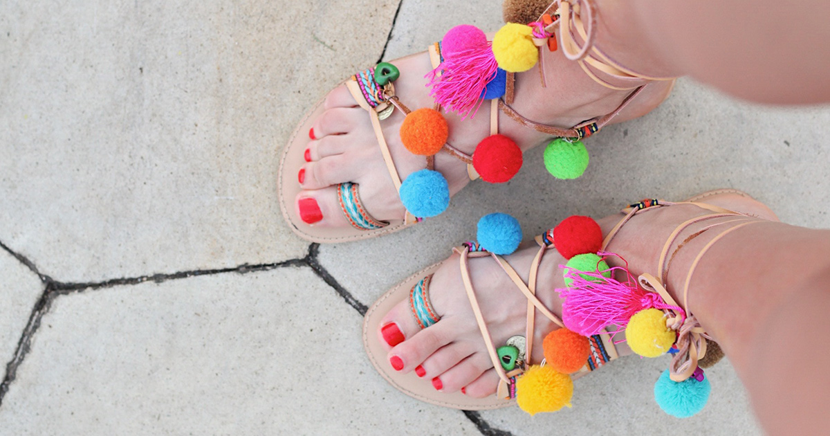 woman with red toenails wearing bright sandals