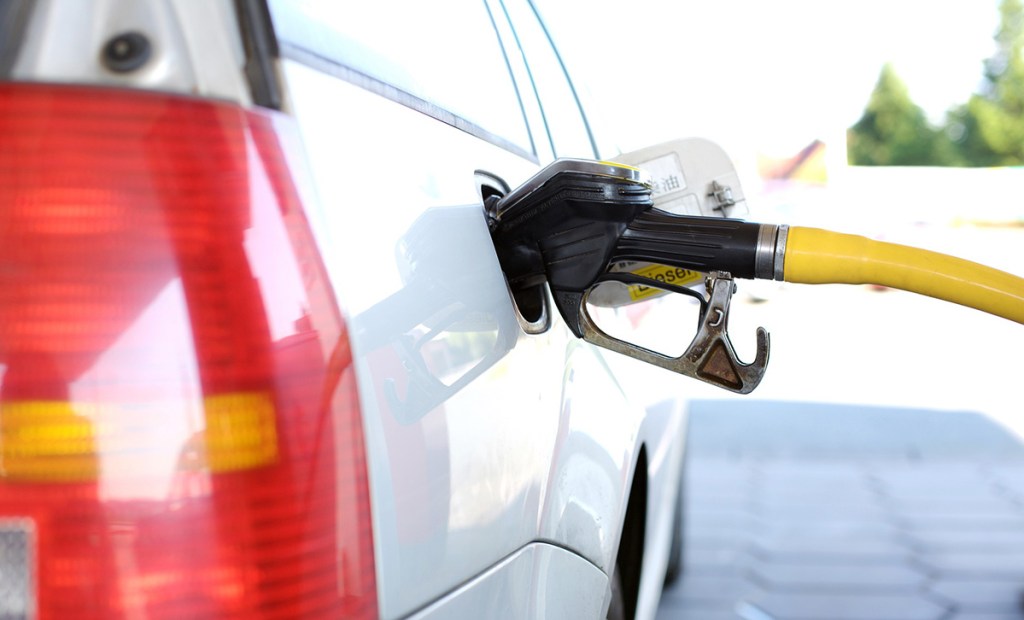 at gas station pumping gas into car