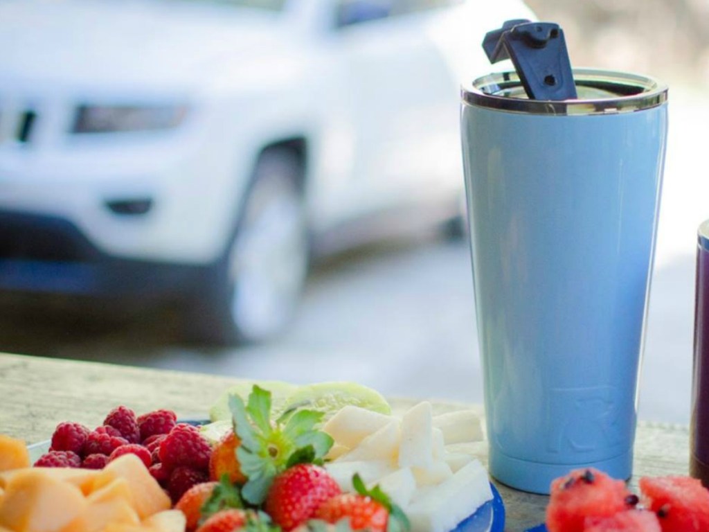 blue water bottle on table with strawberries and cheese