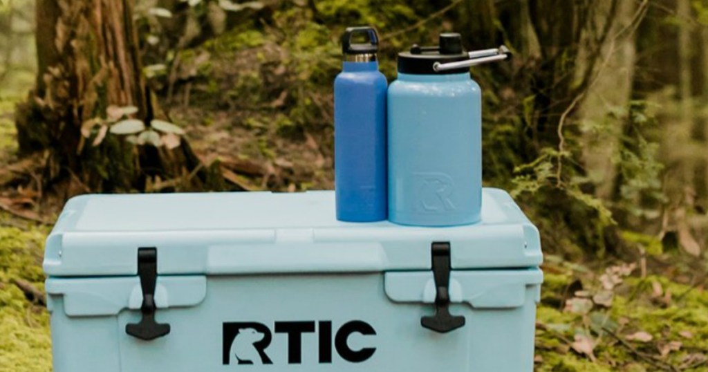 cooler with blue water bottles on it in the woods