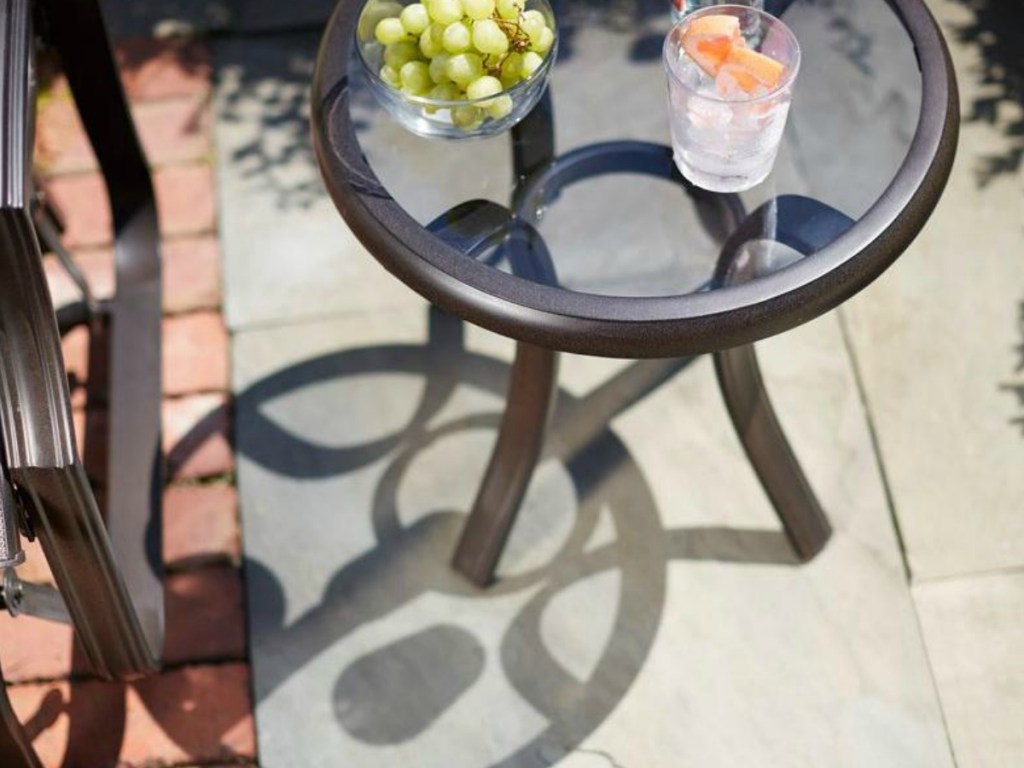 small table with glass and bowl on it outside