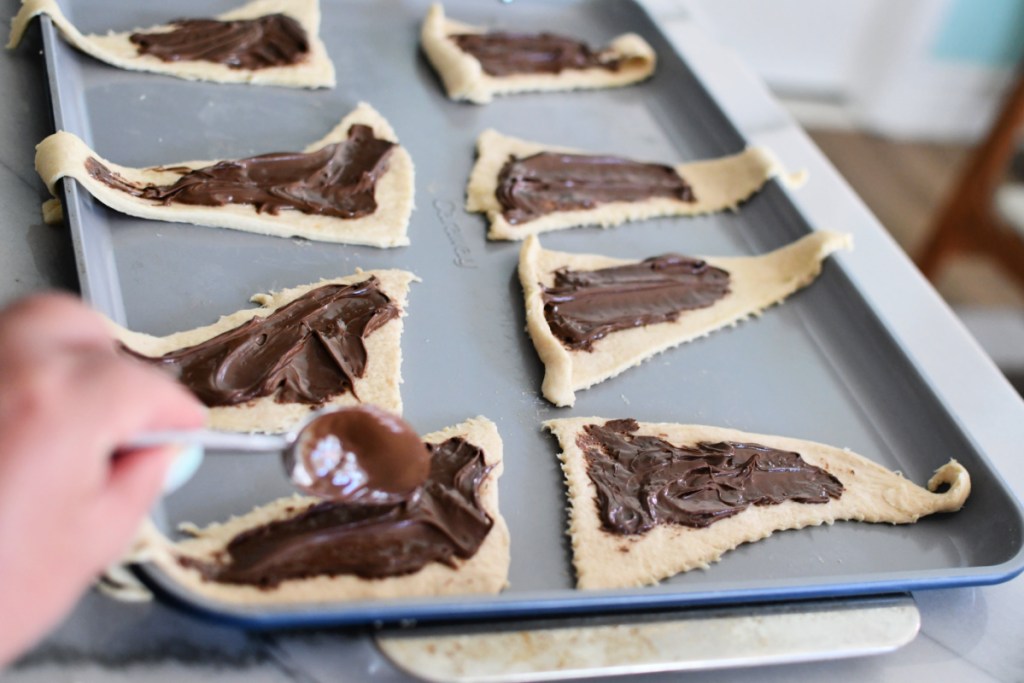 spooning nutella onto crescent rolls