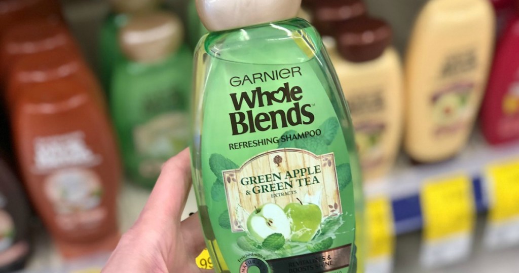 hand holding garnier whole blends shampoo at walgreens