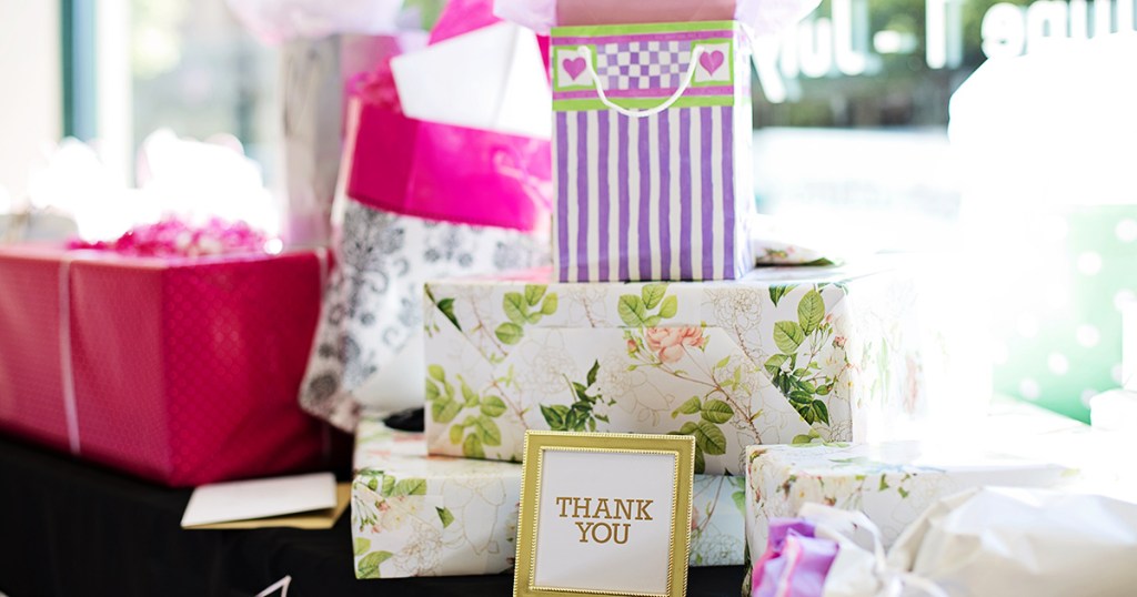 table full of wrapped wedding gifts