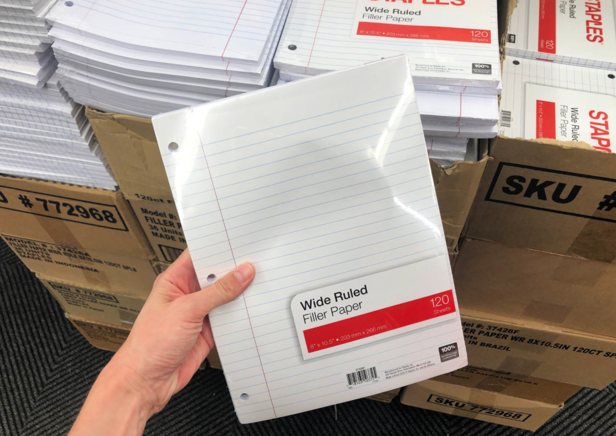 hand holding Staples wide-ruled filler paper